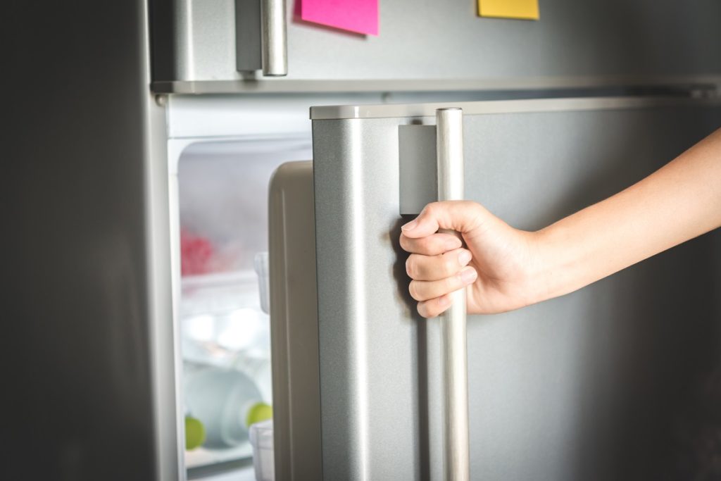 hand opening the refrigerator