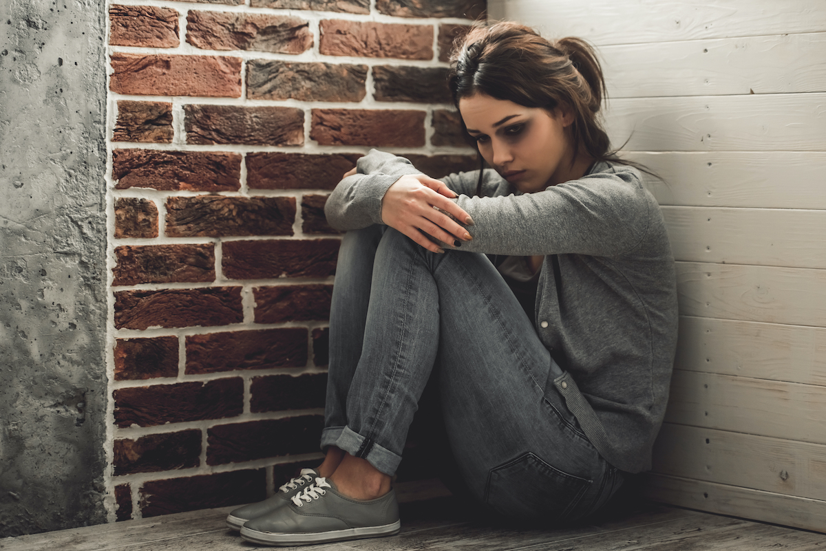 woman sitting in a corner