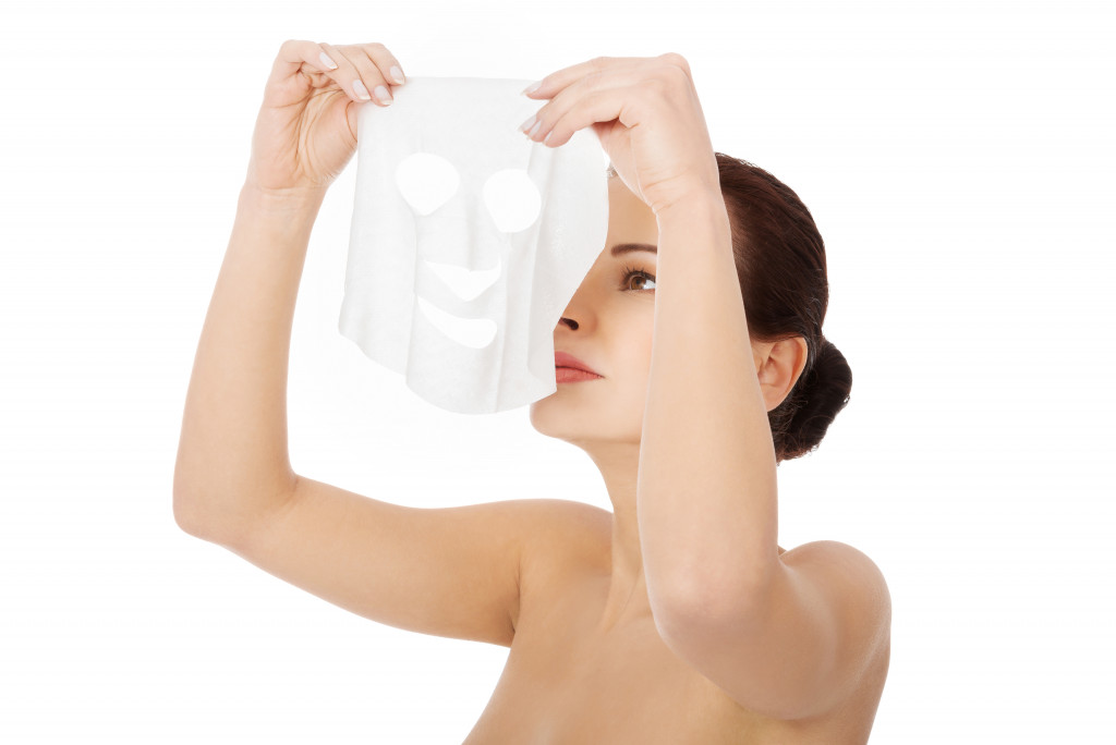 a woman holding a face mask 